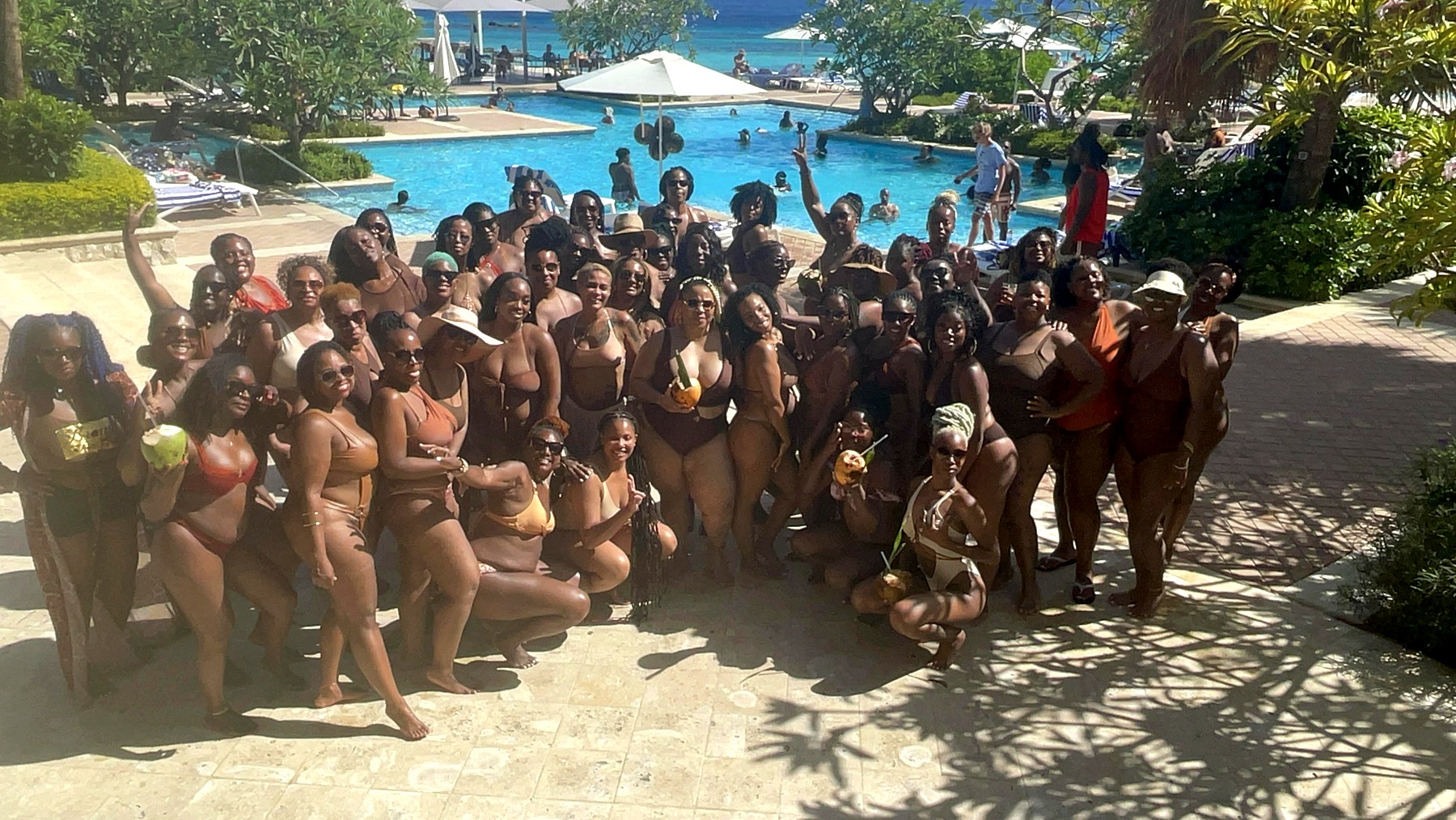 A large group of AFI travelers gathered beside a pool